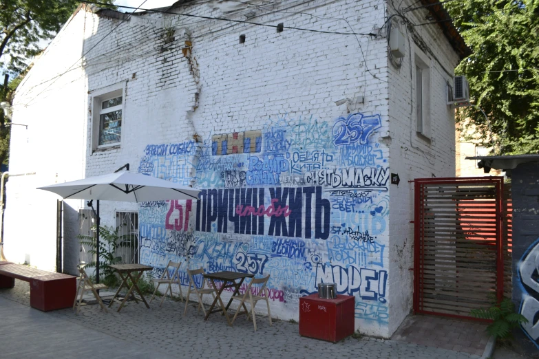 an umbrella on a building's front is covered by graffiti