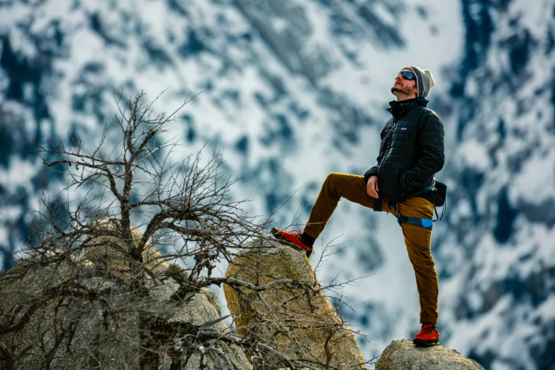 a person is sitting on top of a rock while standing on it