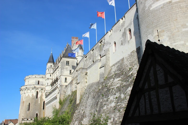 a castle is seen through a window with red flags flying above it