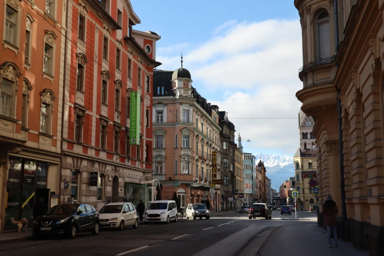 the street is full of parked cars and tall buildings