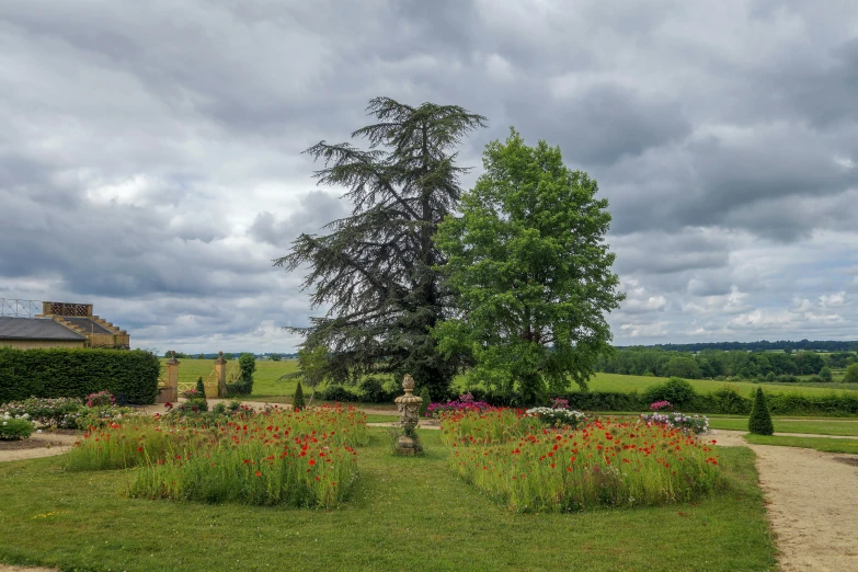 an old church has a path leading to a flower garden