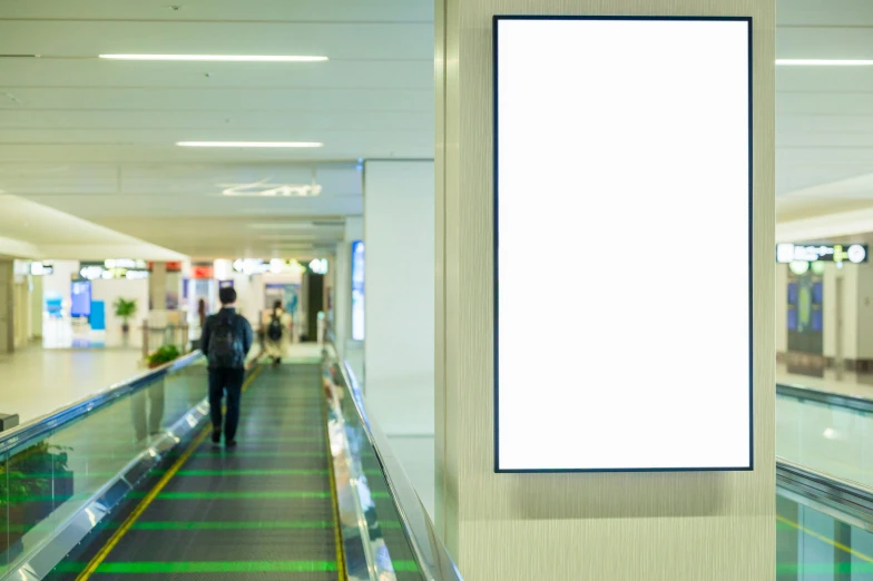 a man walking down a walkway with an empty sign