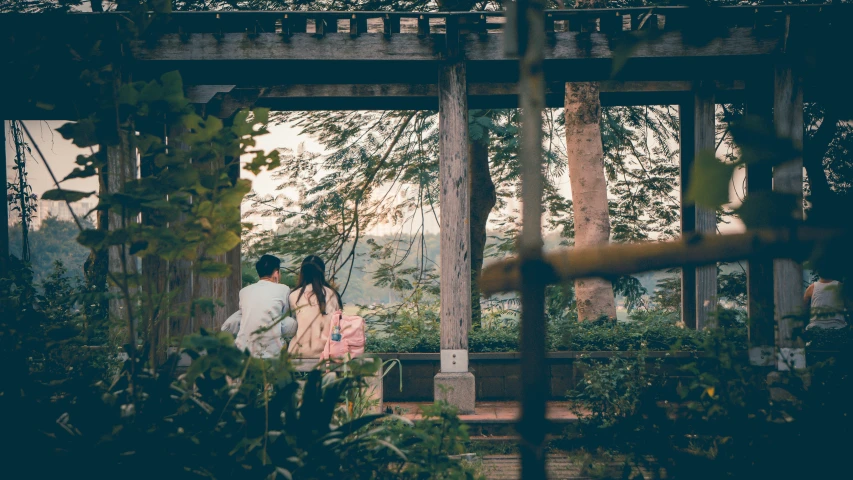 people are walking near an archway in a garden