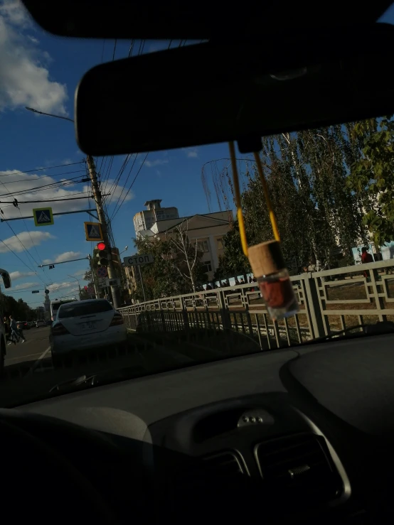 a car's view taken out the windshield of another car with it's hand in the driver's cup