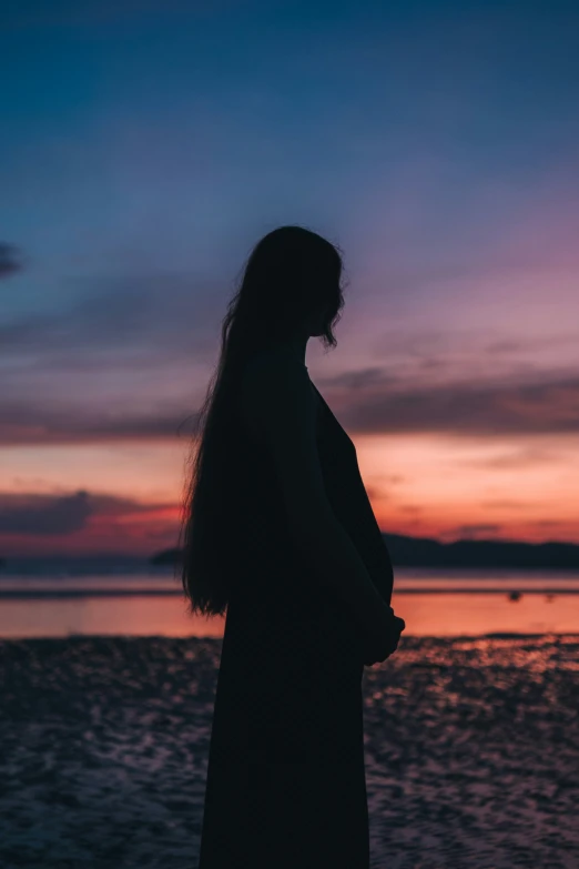 the silhouette of a woman on a sunset background
