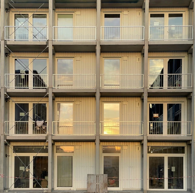 a large brown and white building that has multiple balconies