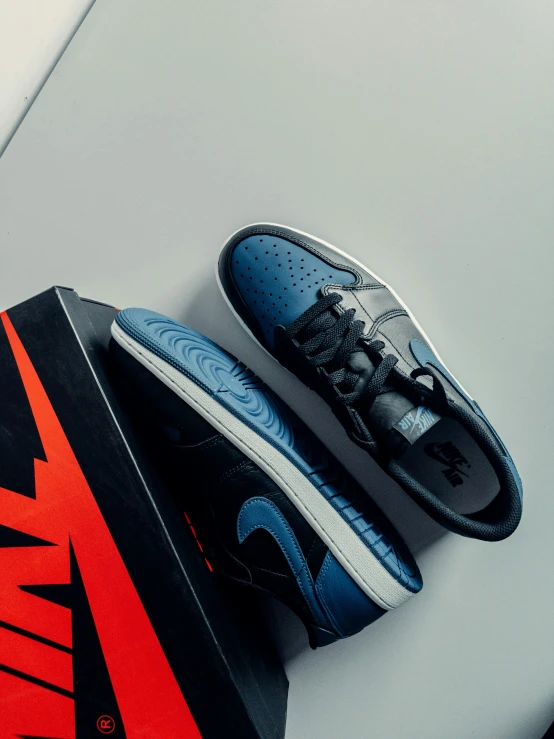 a pair of black, blue and red sneakers with a red nike shoe box
