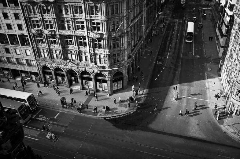 a black and white image shows people crossing a city street