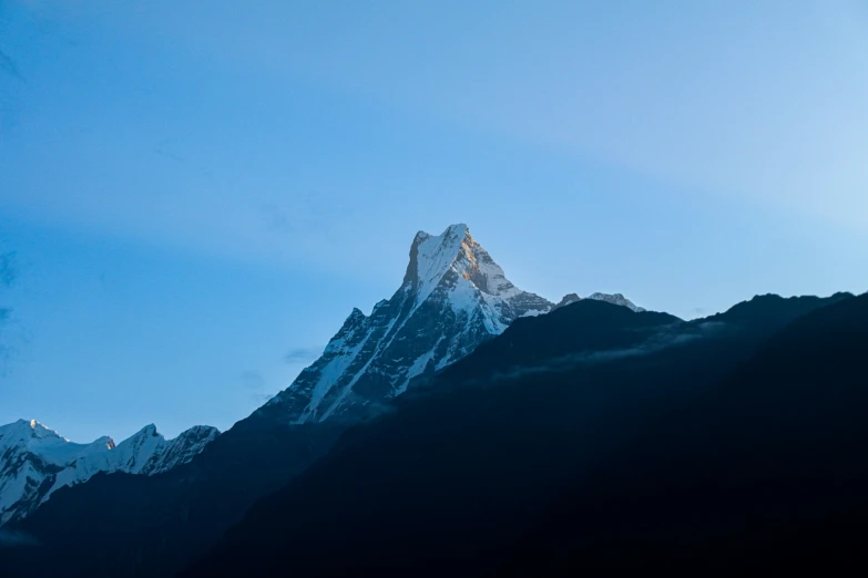 the top of a snow covered mountain, with clear blue skies