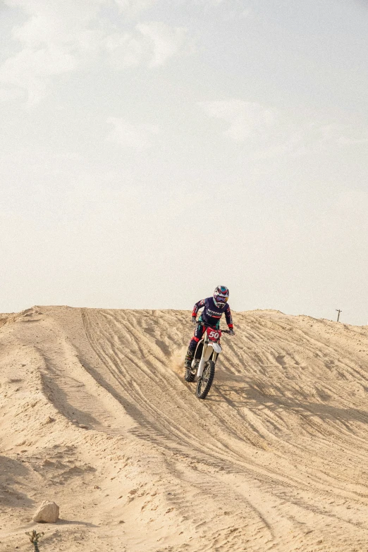 a person riding a bike in the sand