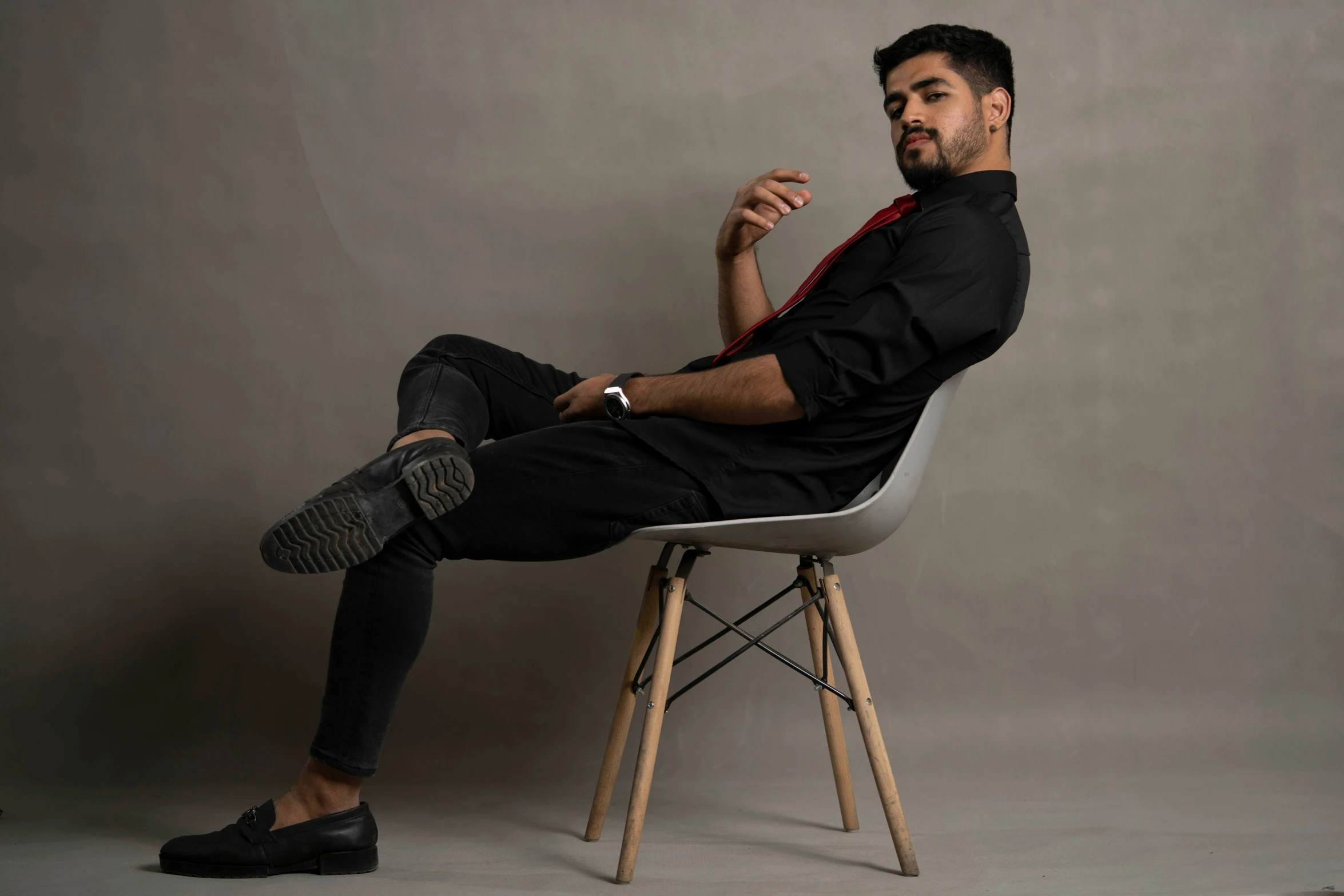 a man wearing all black sitting in a chair