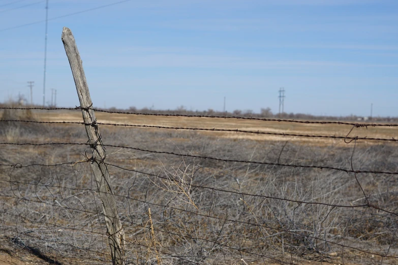 an old fence in the distance next to a field