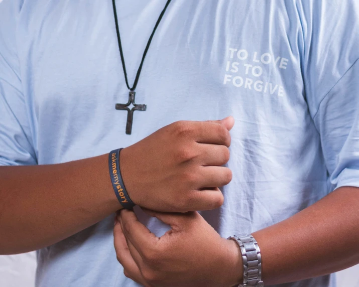 a man is holding onto his celets while wearing a cross