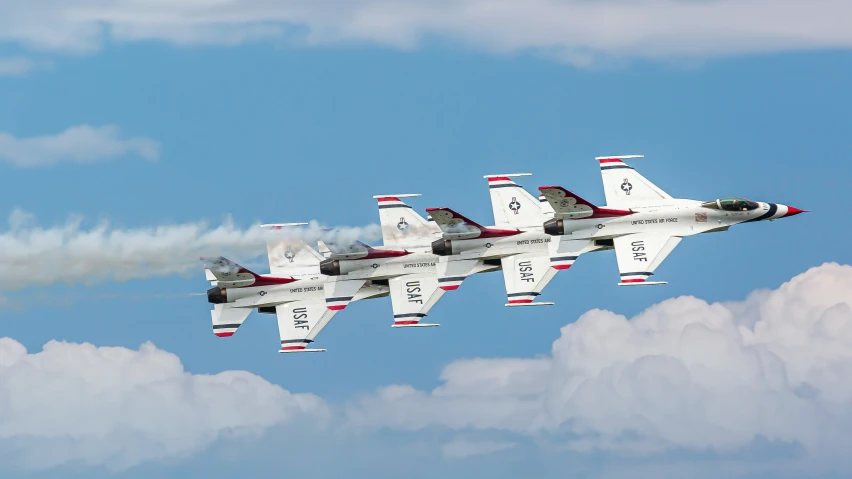 four jet planes flying in formation on a clear day