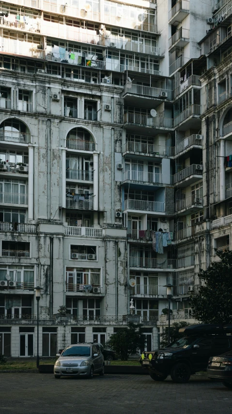 two cars driving in front of an old building