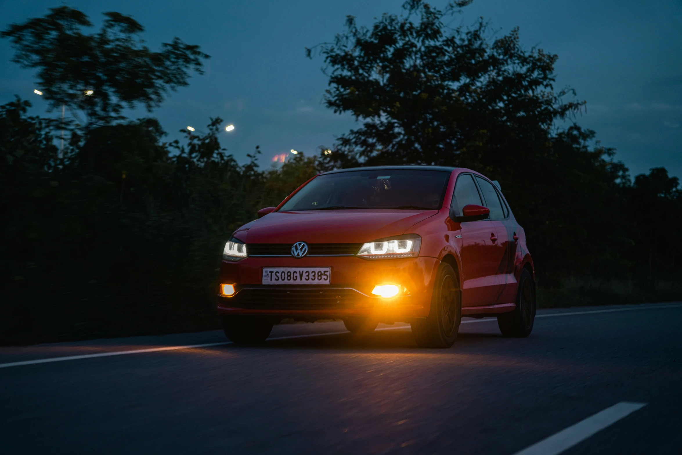 a red golf wagon is driving down the street