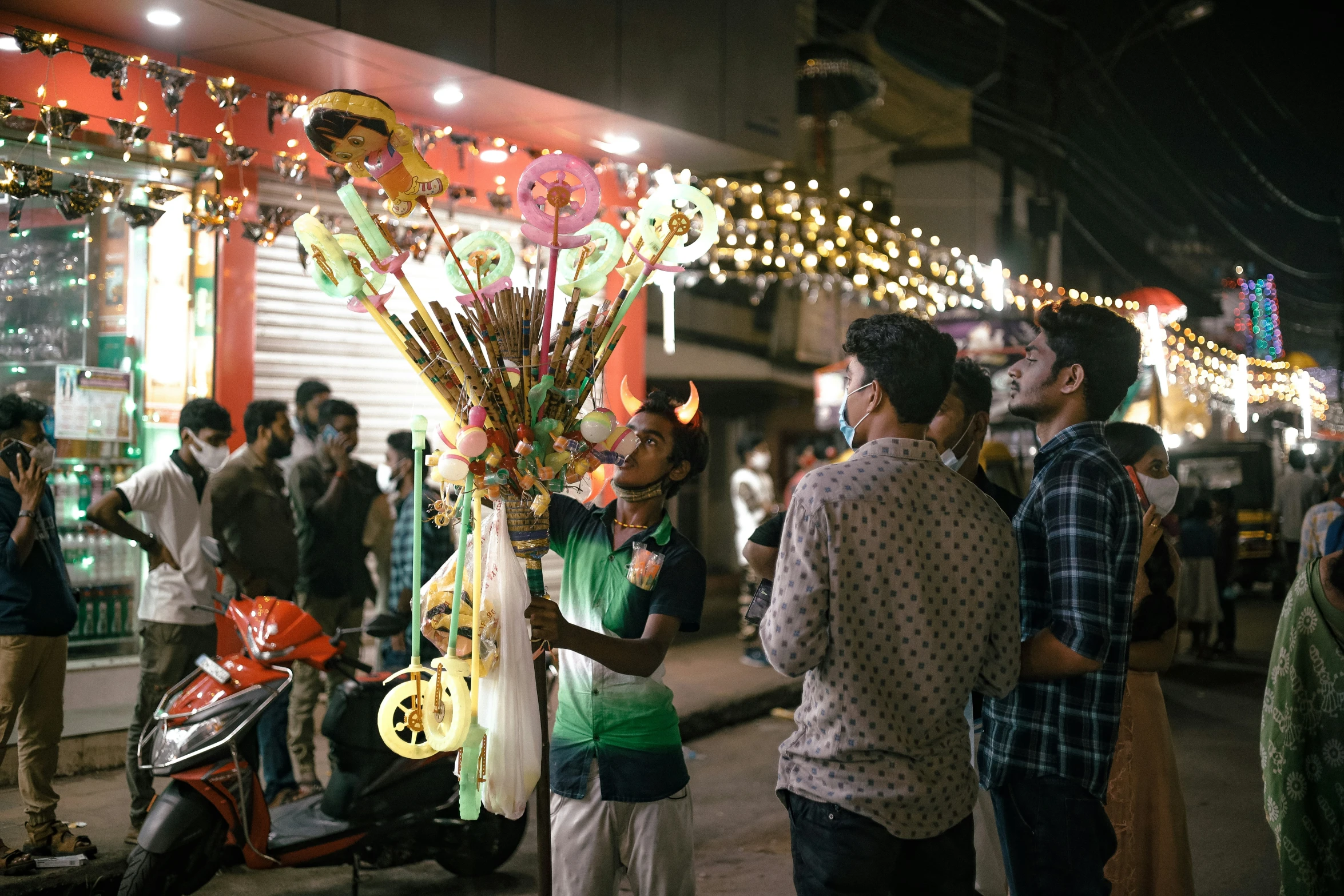 a group of people standing around a street filled with lights