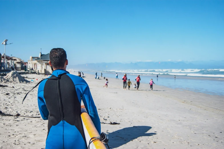 a person on the beach carrying a surfboard