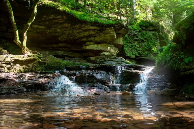 a small waterfall is coming out of a creek