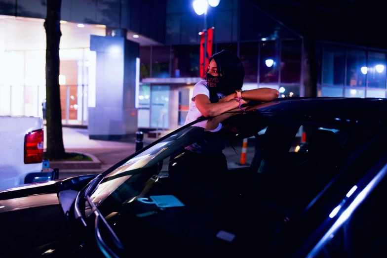 a man standing behind his car at night