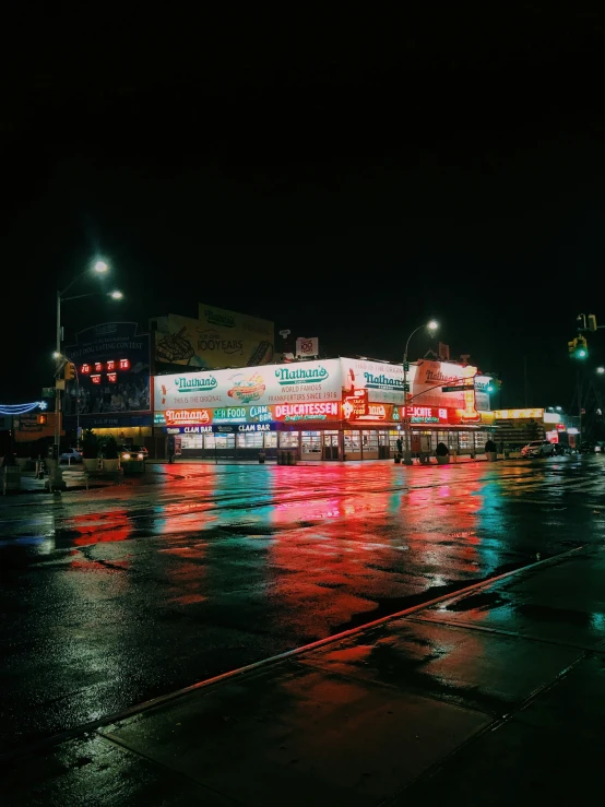 a street at night with some traffic lights in the rain