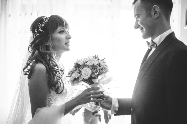 a bride holding her bouquet and standing next to her groom