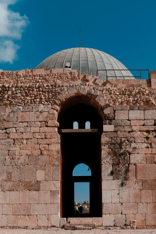 view from outside of the archway with clock on the stone wall