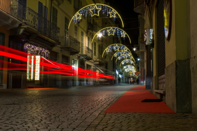 red lights are hanging over the street at night