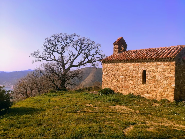 a stone building standing on the side of a hill