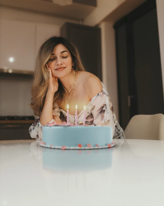 a beautiful young woman sitting in front of a birthday cake