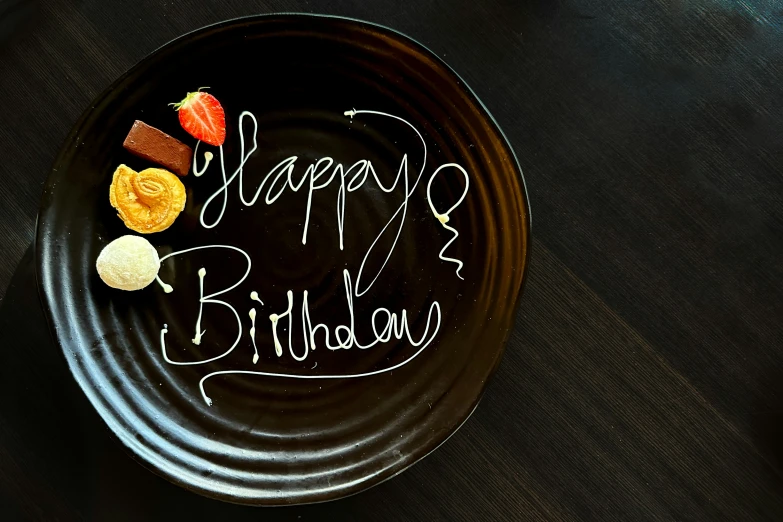 the happy birthday plate is on the table with some small cookies