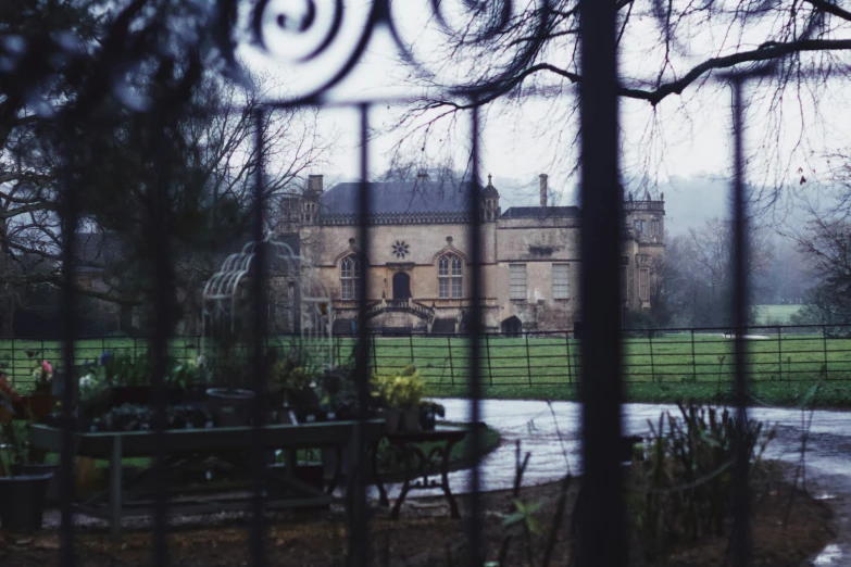 the view from behind a gate of an old mansion