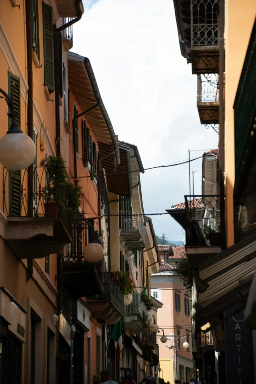 people walking along side of buildings next to a street