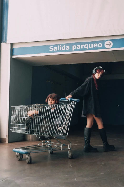 a woman hing a shopping cart through a store front