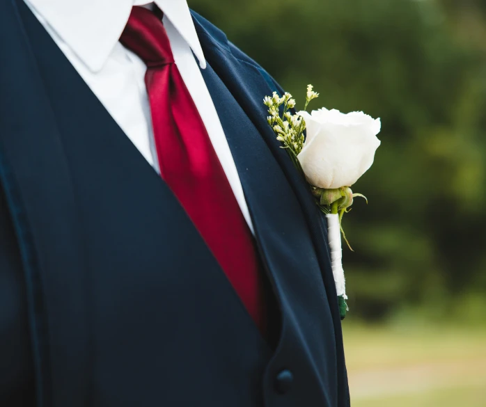 a man with a white flower in his lapel coat