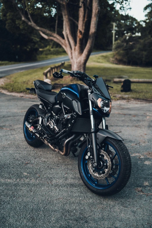 a blue and black motorcycle sitting on the side of the road