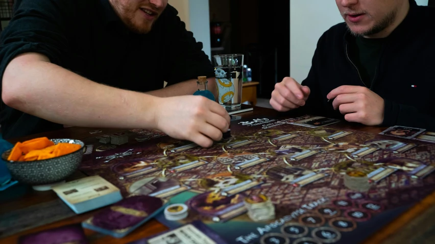 two guys looking at some cards on a table