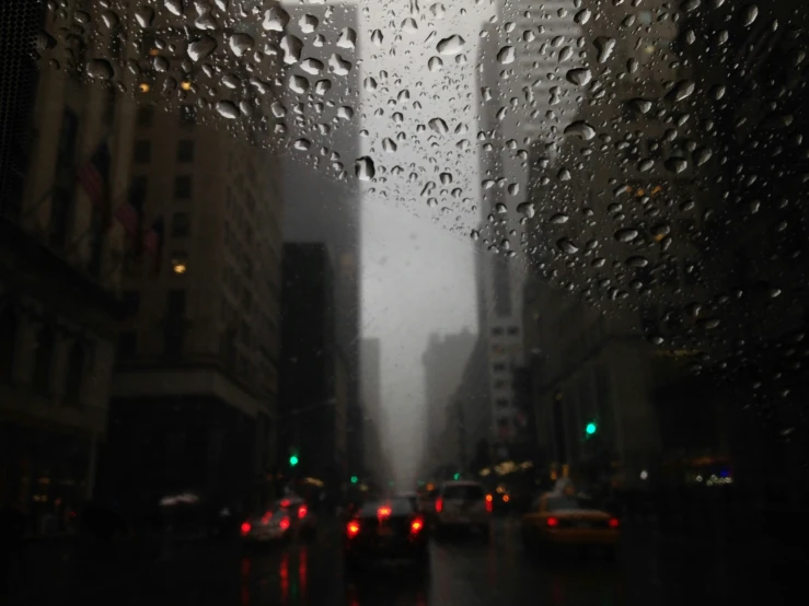 a rain - soaked city street with cars and traffic