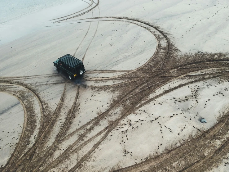 an aerial view of a tractor in the sand