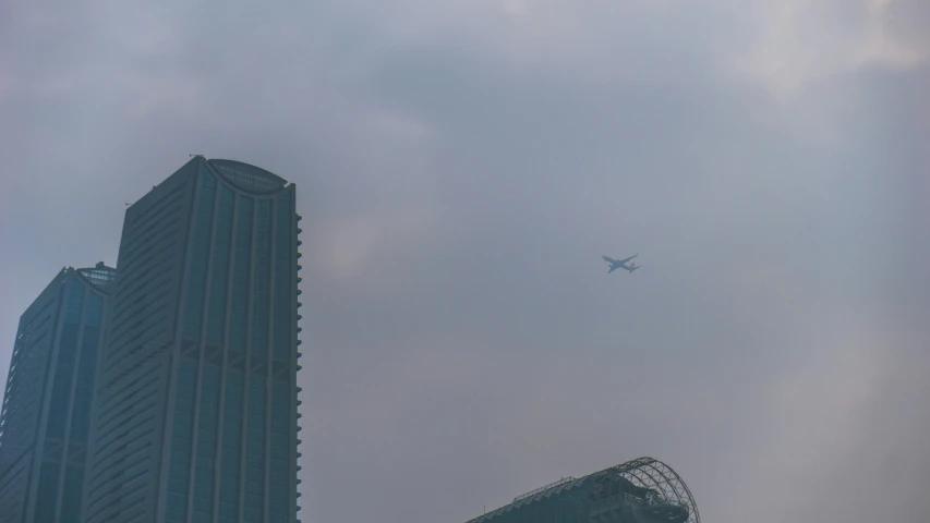 an airplane flies over some high rise buildings