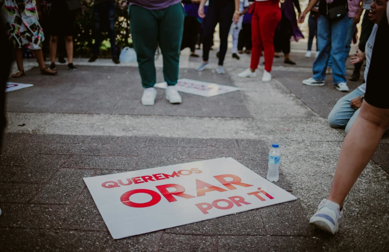 a protest sign laying on the ground next to people walking