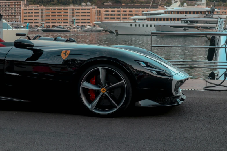 a black sports car parked next to a large body of water