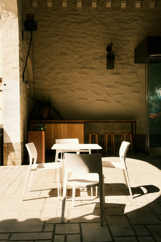 a patio with a table and two chairs in the sunlight