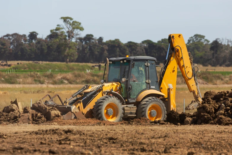 the large machine is digging earth in the field