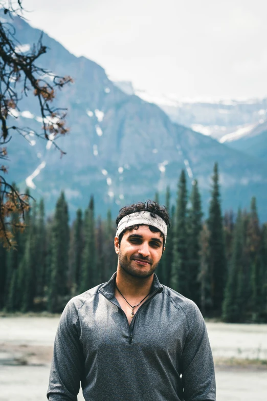 a man stands in front of a scenic view of some mountains