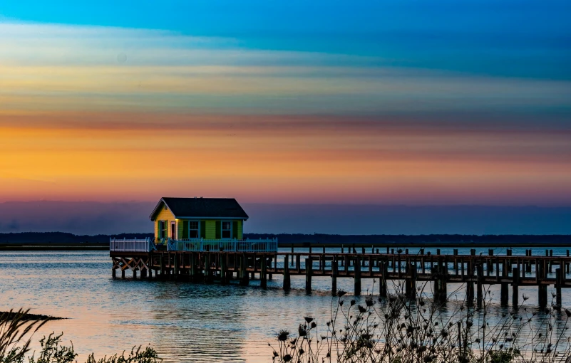 a house on top of a pier by the ocean