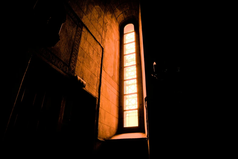 an arch between two buildings with a window lit up