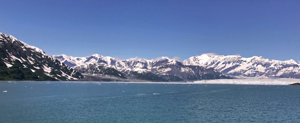 snow capped mountains rise above a large body of water