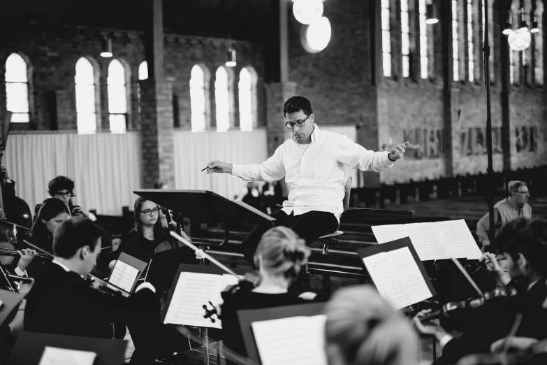 conductor with instruments and music students in a cathedral