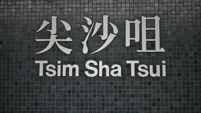 a subway sign with a japanese writing and english writing